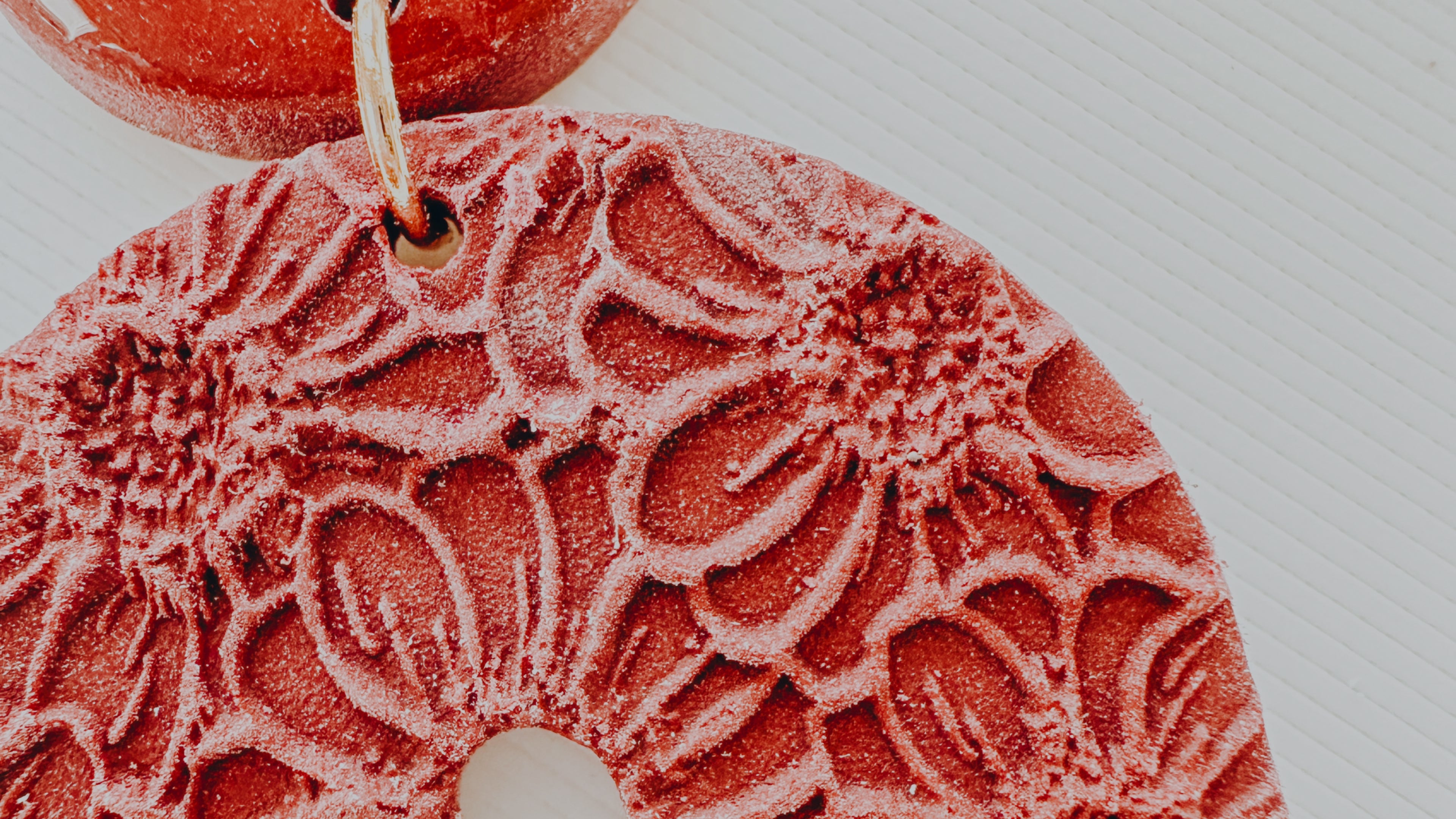 A close up image of a finished polymer clay cutter featuring embossed floral design.
