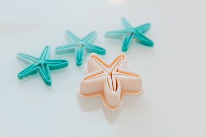 Star Fish Shape clay cutters in teal and peach on a white background